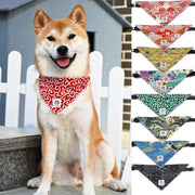 Shiba Inu wearing a red Japanese tang grass patterned pet bandana with various colorful pet bandanas displayed beside it